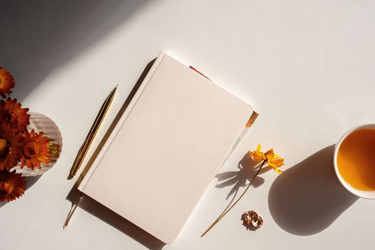 Styled notebook or journal flat lay with copy space, fall theme, contrast light
